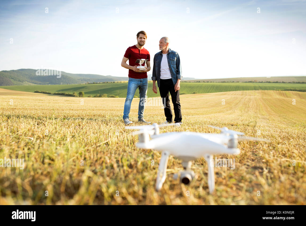 Senior father and his adult son with drone on a field Stock Photo - Alamy