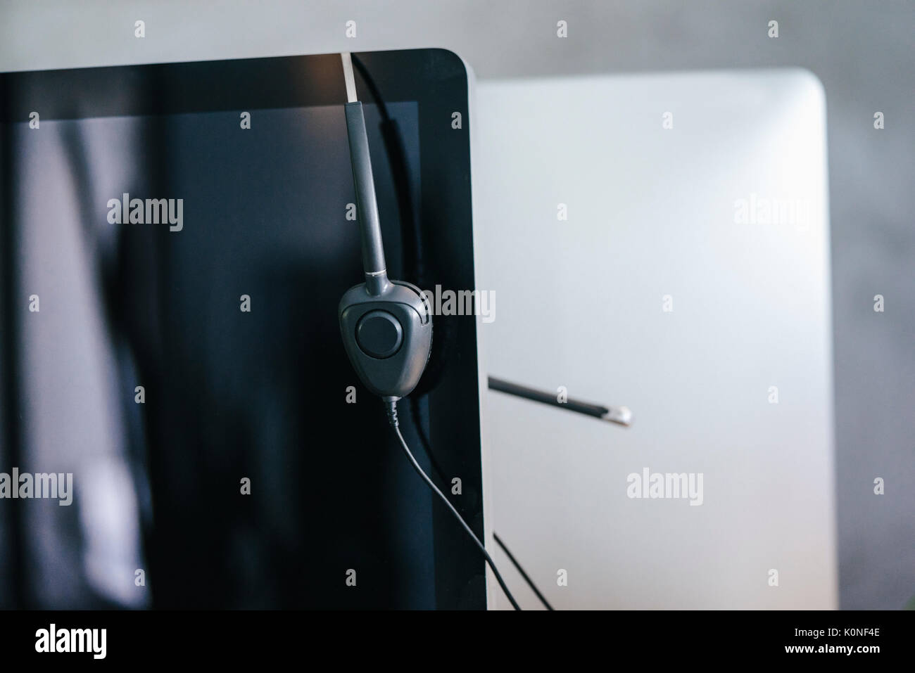 Workspace with headset hanging from computer Stock Photo - Alamy