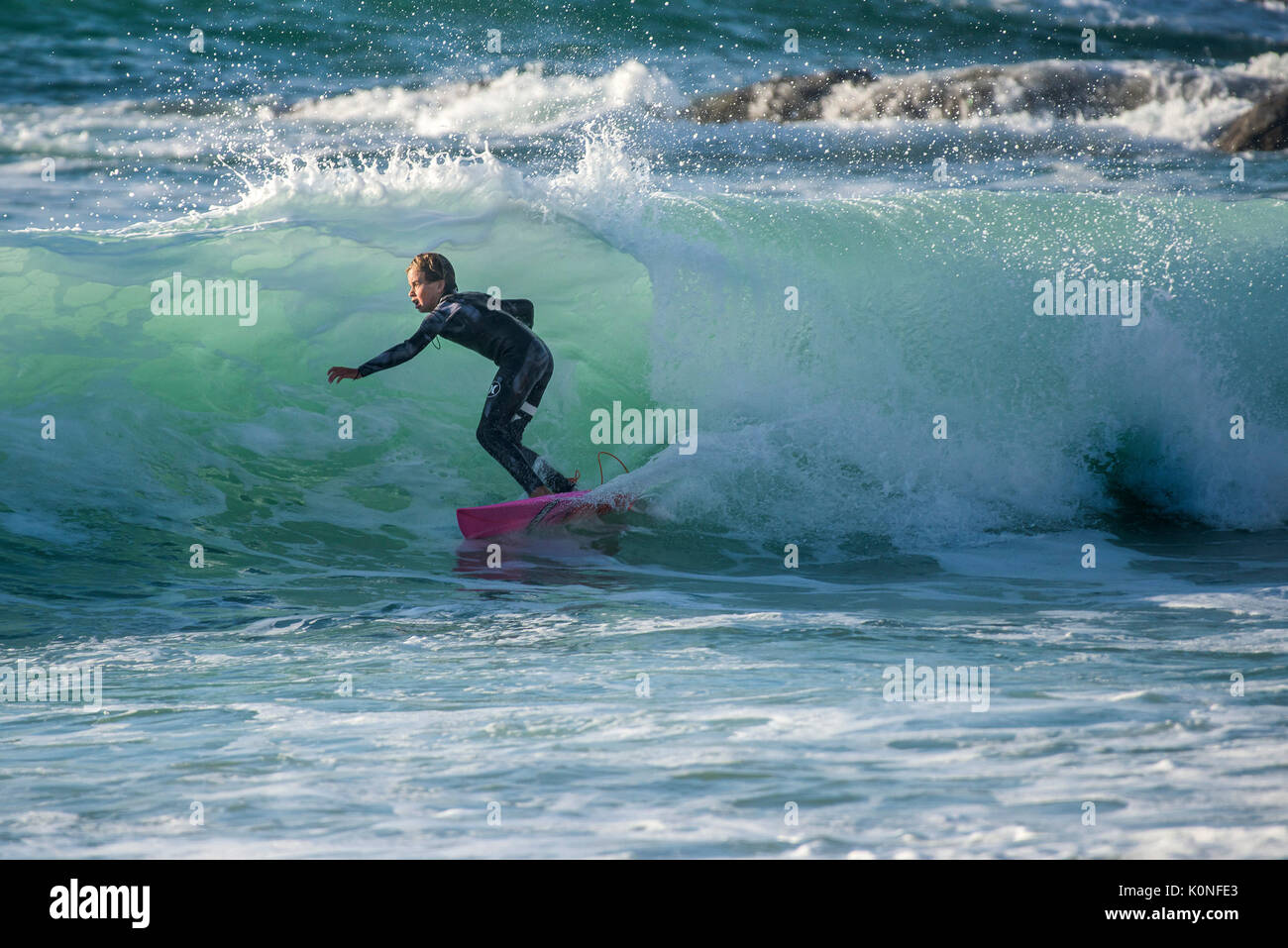 Surfing UK - A surfer riding a wave at Fistral Cornwall UK. Stock Photo