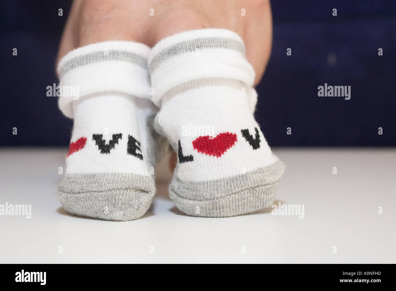 hands holding small baby socks Stock Photo Alamy
