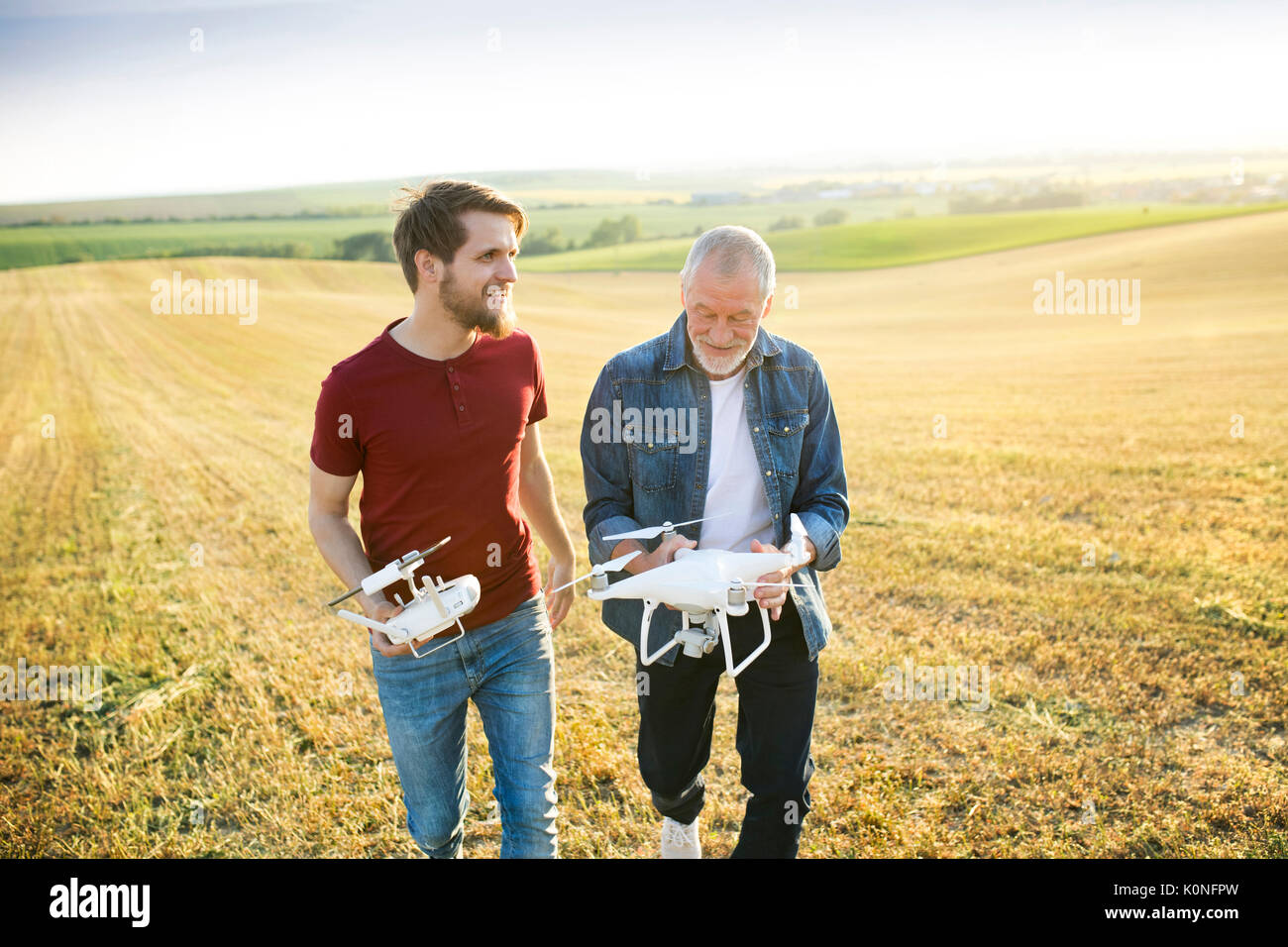 Senior father and his adult son with drone on a field Stock Photo - Alamy