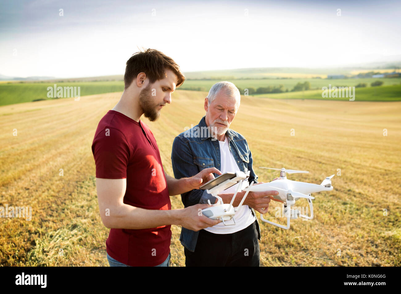Senior father and his adult son with drone on a field Stock Photo - Alamy