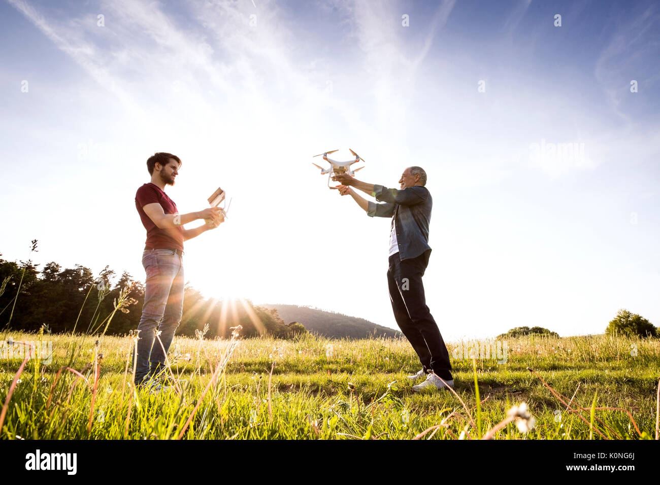 Senior father and his adult son with drone on a meadow Stock Photo - Alamy
