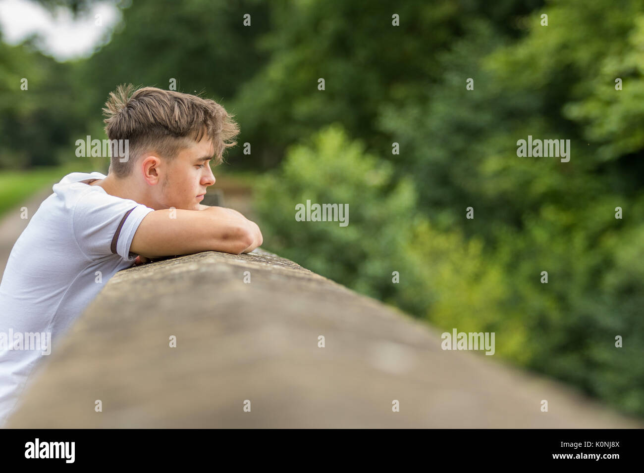 Teenage boy in a park on a warm summers day Stock Photo