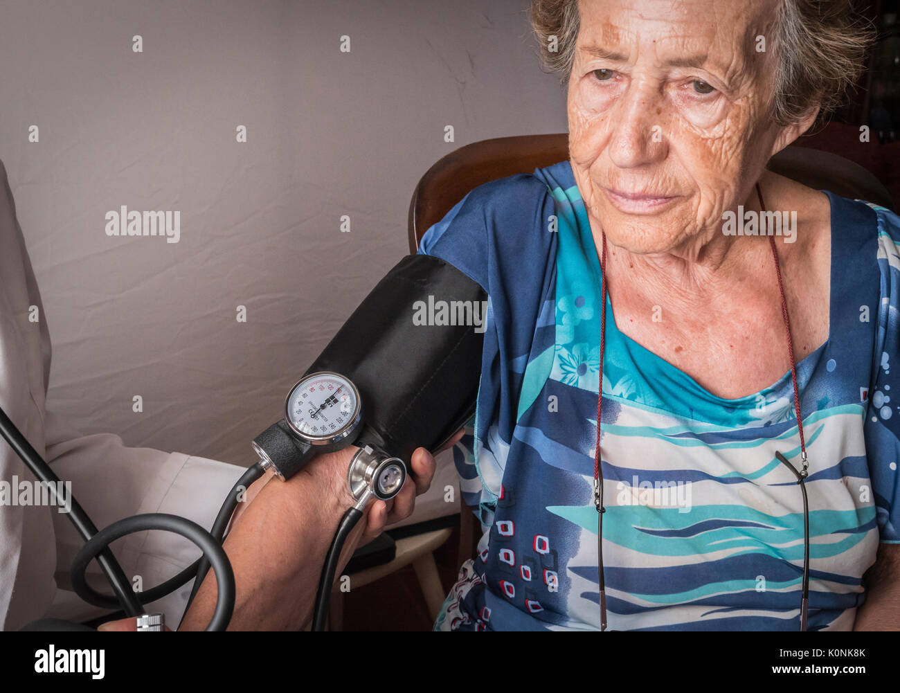 Doctor measures the arterial tension to oldster at home, Andalusia, Spain Stock Photo