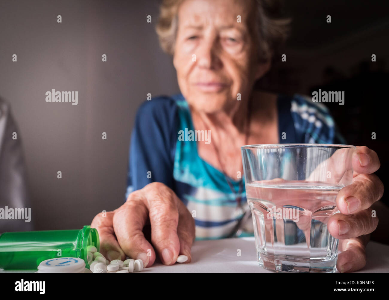 Oldster taking daily medication dose at home, Andalusia, Spain Stock Photo