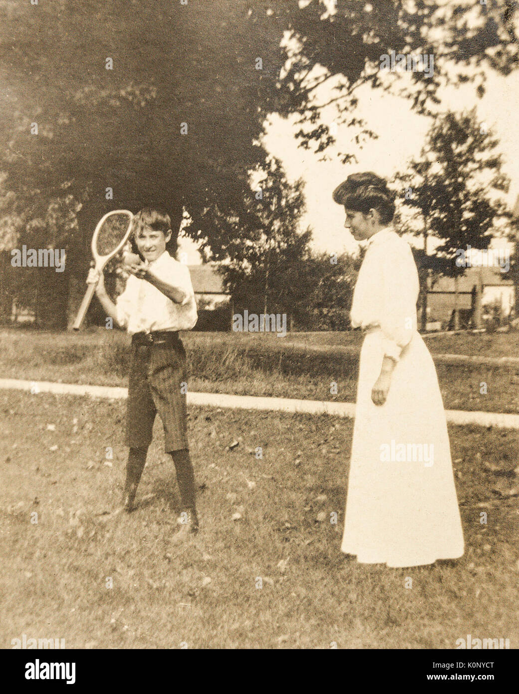 A young boy with a tennis racket and ball in 1907 1908 with a young  woman Stock Photo