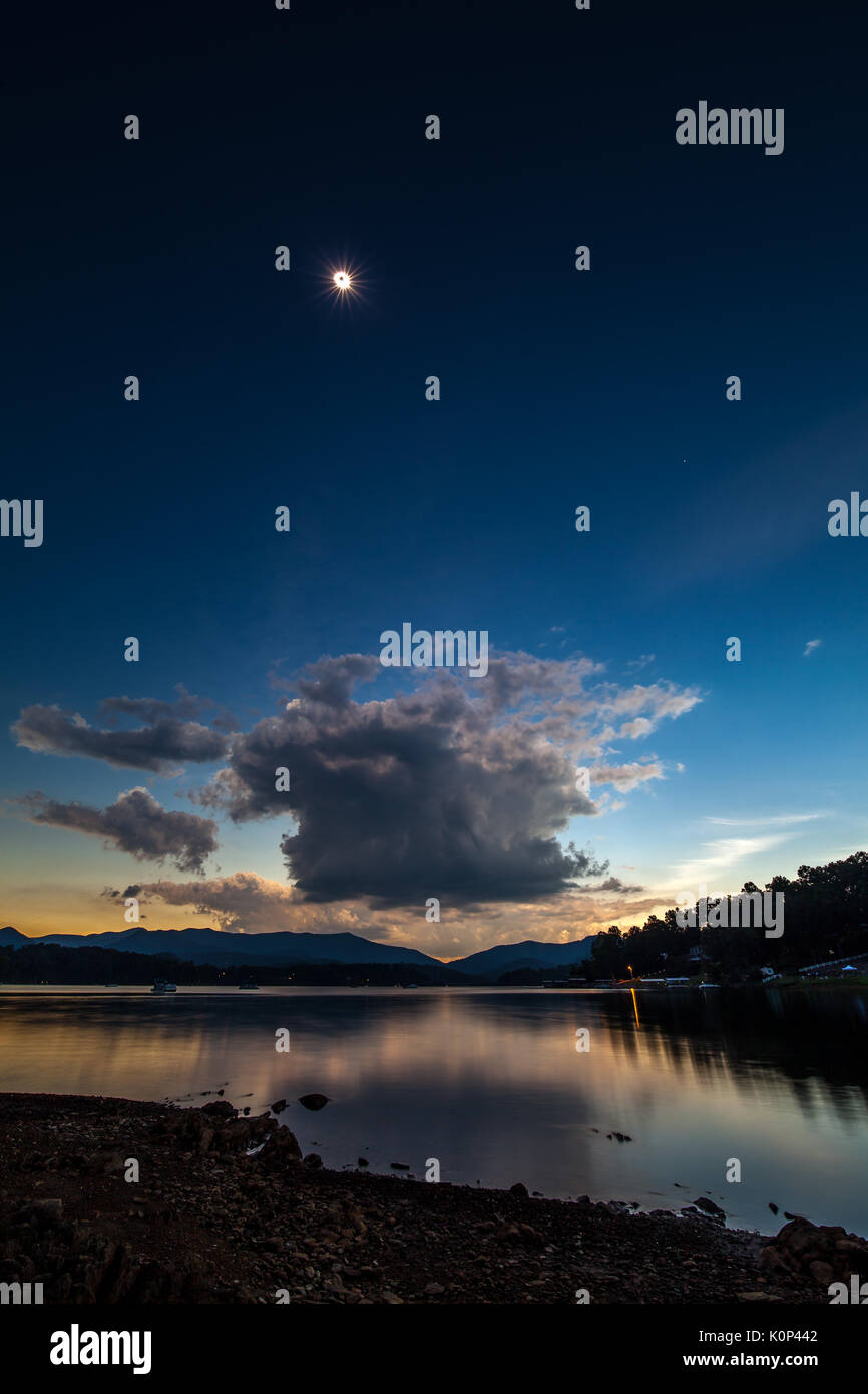 This image is one frame, not a composite image.  The 15mm lens allowed capturing the foreground and lake as well as the sun in the sky.  The angle to the sun at this point was about 66.5 degrees above the horizon.  The 100 degree field of view was needed to get everything in the frame.    The solar eclipse of 2017 passed across the entire United States from the northwest to the southeast.  The path of totality was approximately 70 miles wide and totality lasted a maximum of approximately 2' 30' depending on location.  Lake Chatuge is a 7500 acre lake created in 1942 when the Tennessee Valley A Stock Photo