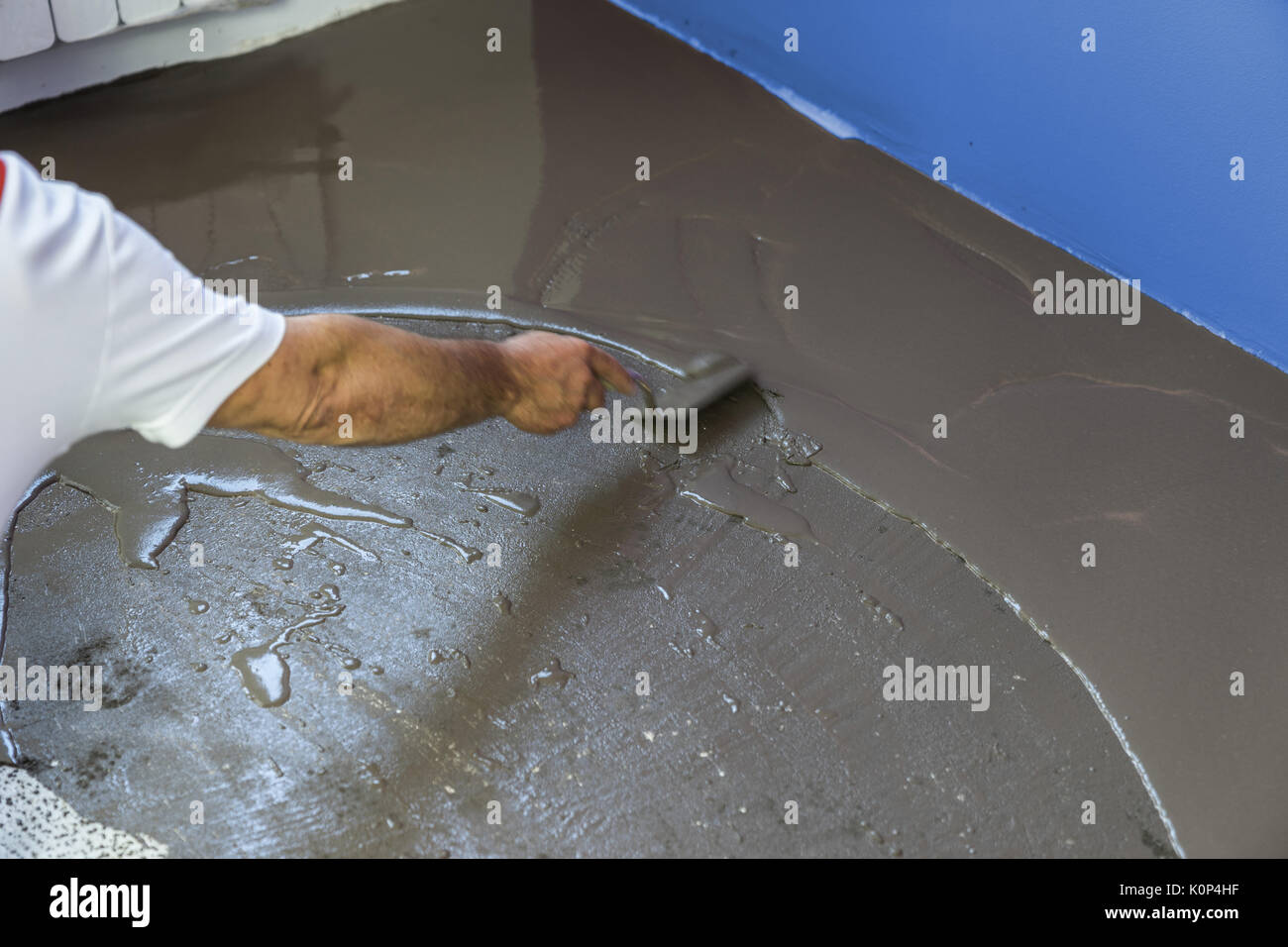 Worker Puts A Self Leveling Screed On Cement Floor In House Stock