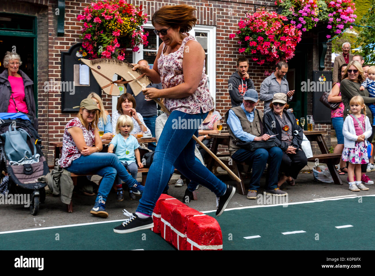 Local People 'Showjumping' With A Toy Horse At The Annual South Street Sports Day and Dog Show, Lewes, East Sussex, UK Stock Photo