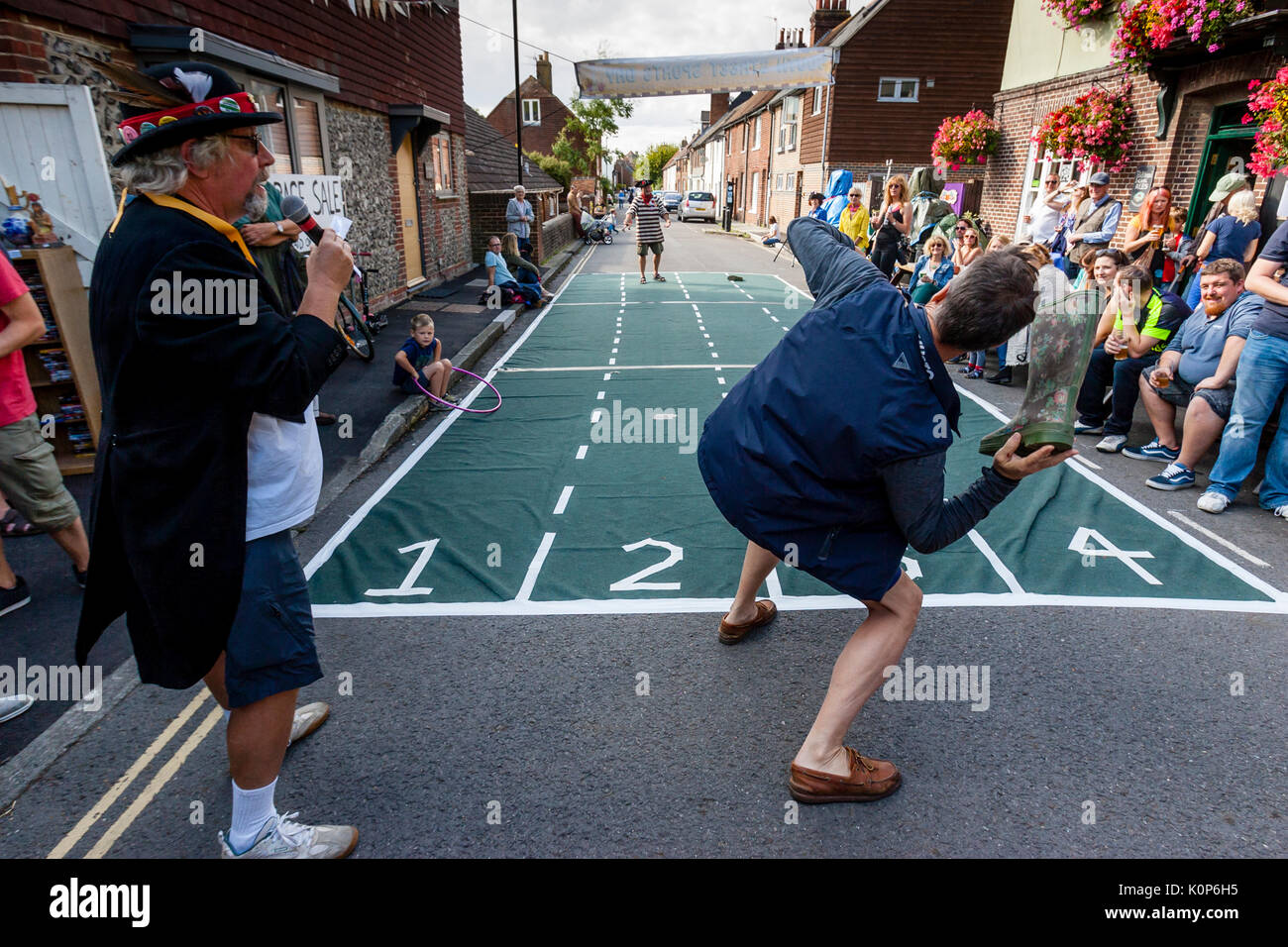 Local People Take Part In A 'Welly Throwing' Competition At The Annual South Street Sports Day and Dog Show, Lewes, East Sussex, UK Stock Photo
