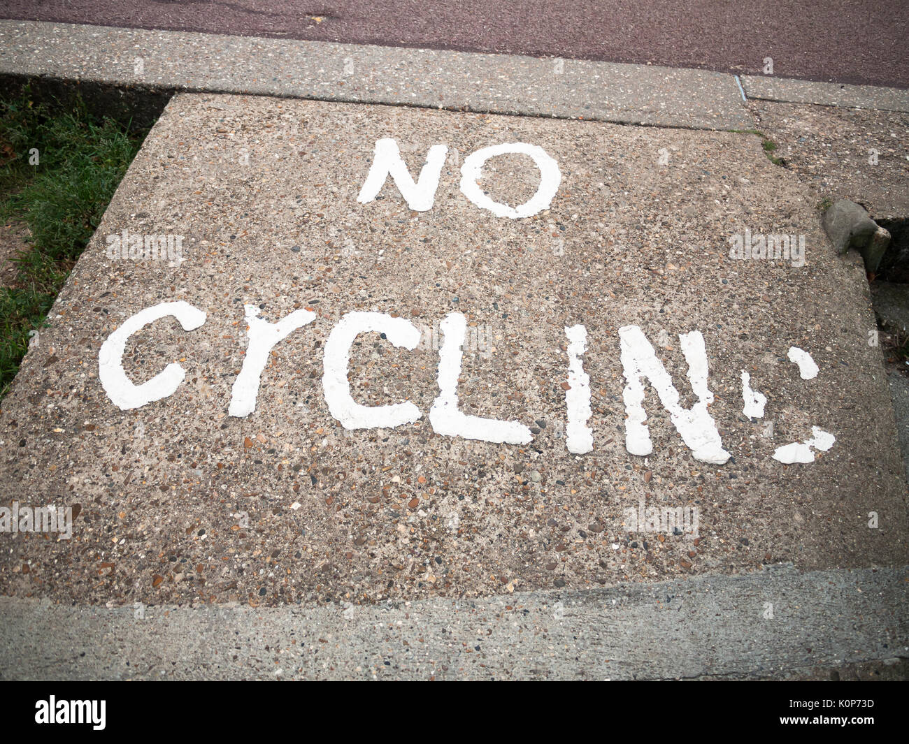 an old and faded sign printed on the floor saying no cycling; England ...