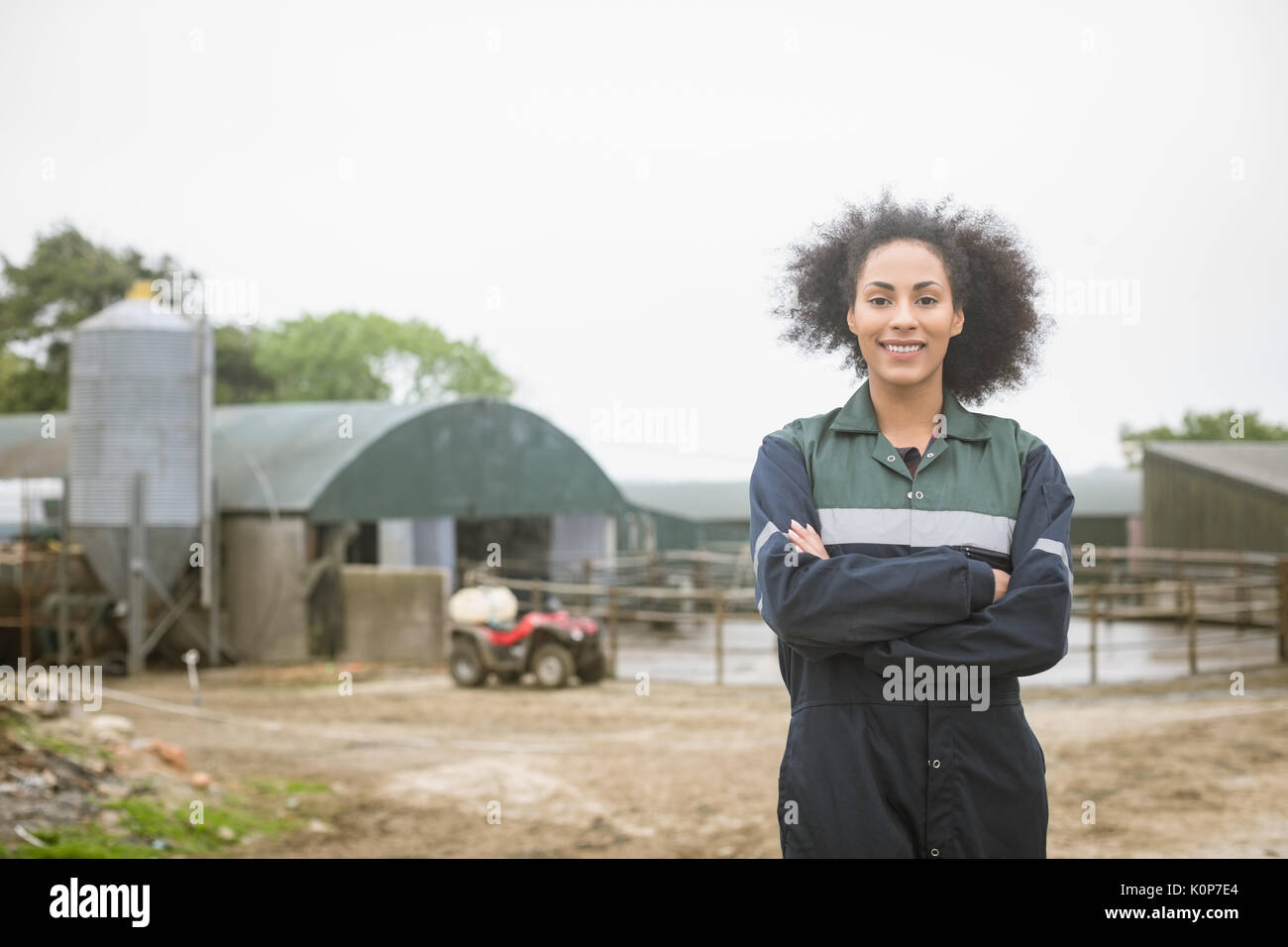 Portrait of woman standing with arms crossed in field Stock Photo - Alamy