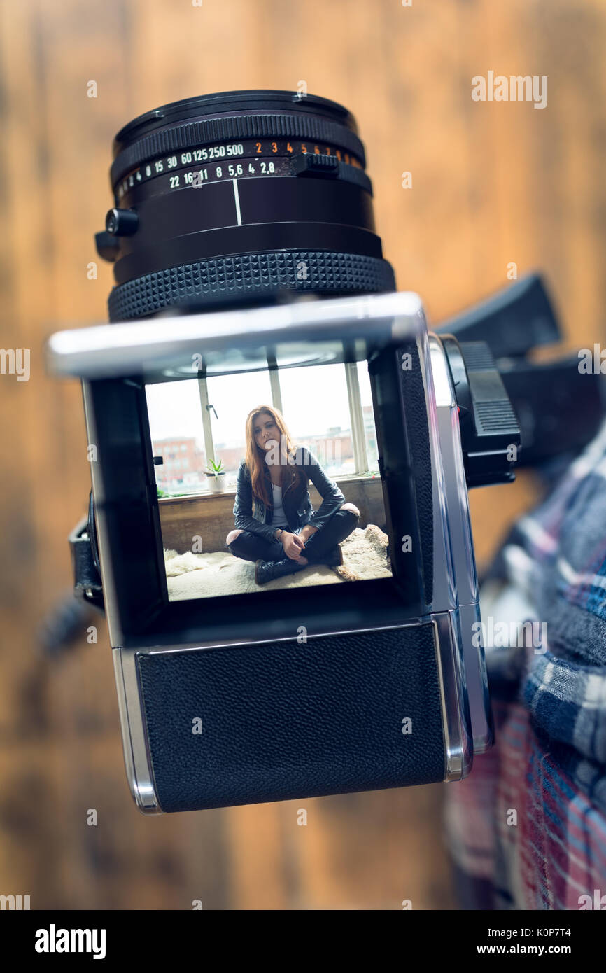 Cropped image of photographer by camera on tripod in studio Stock Photo