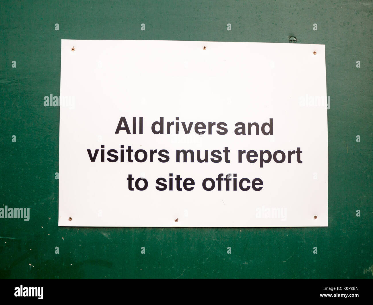 close up of white placard sign all drivers and visitors must report to site office; England; UK