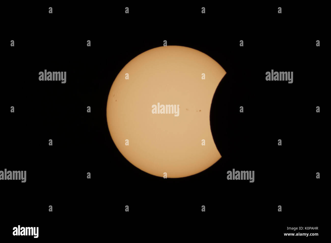 The Moon begins to cover the Sun's disk in the partial eclipse phase after first contact during the Great American Eclipse on August 21, 2017. Stock Photo