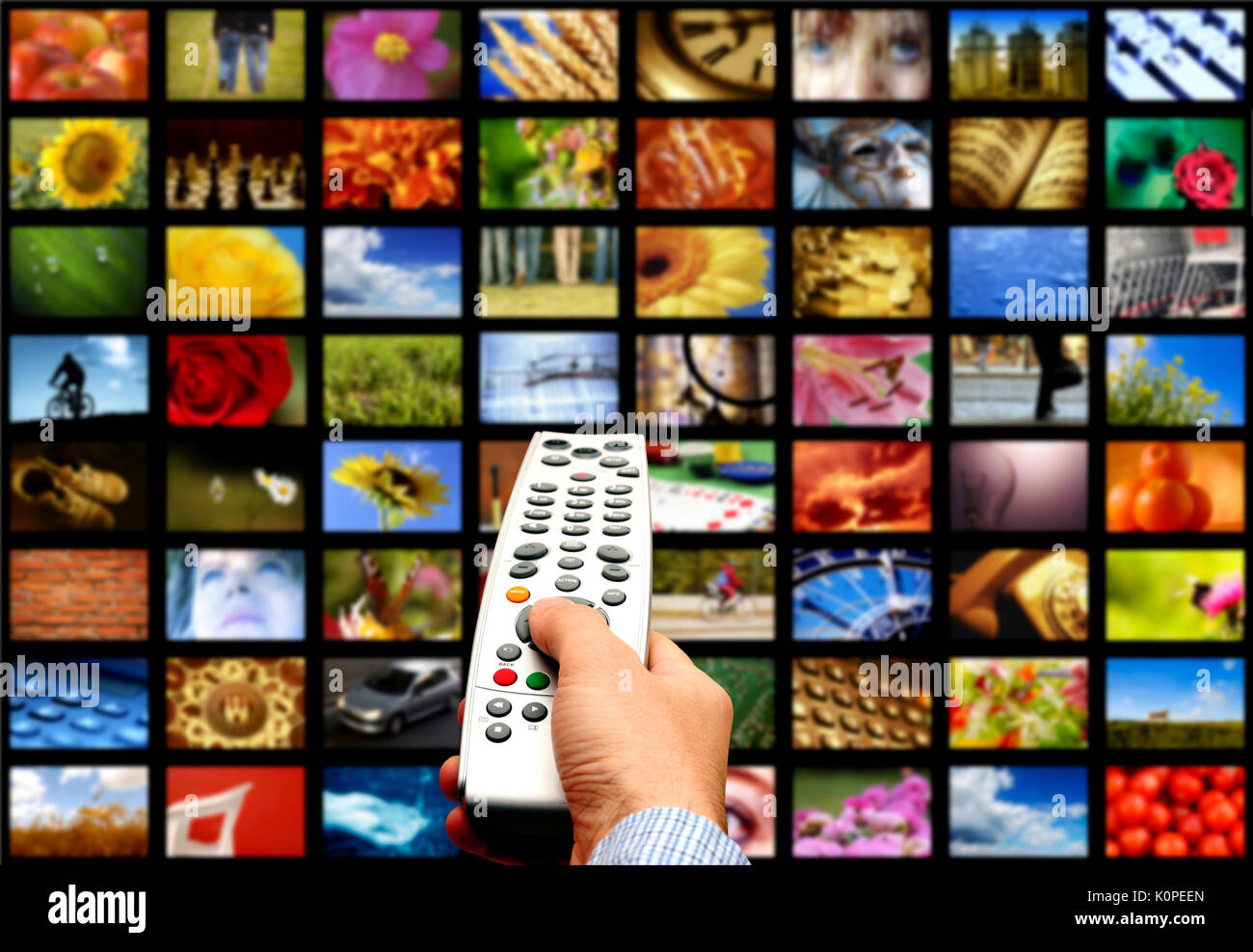 television screens and male hand holding a remote control Stock Photo