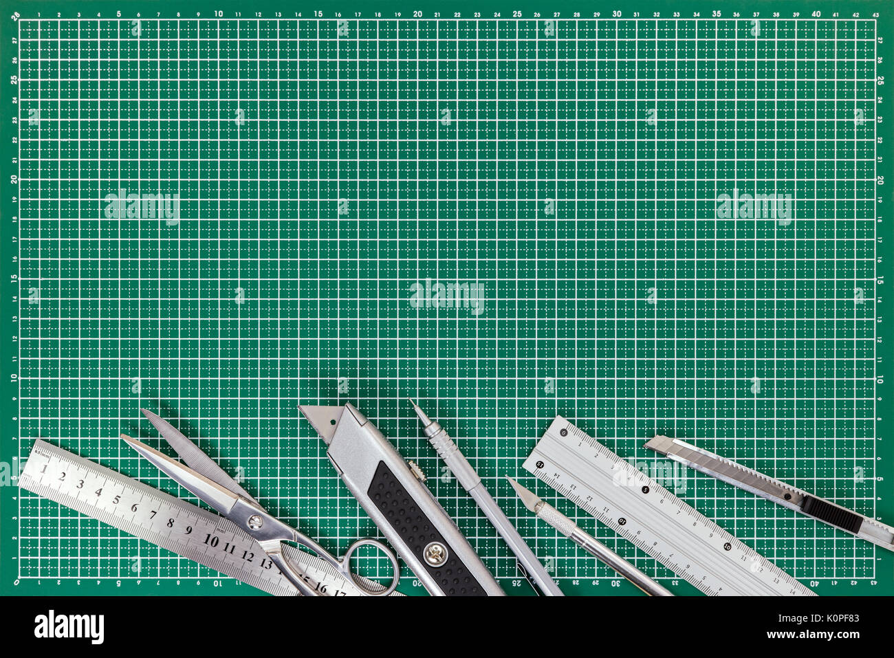 office supplies on cutting mat - cutters, scissors, mechanical pencil, metal ruler. top view. Stock Photo