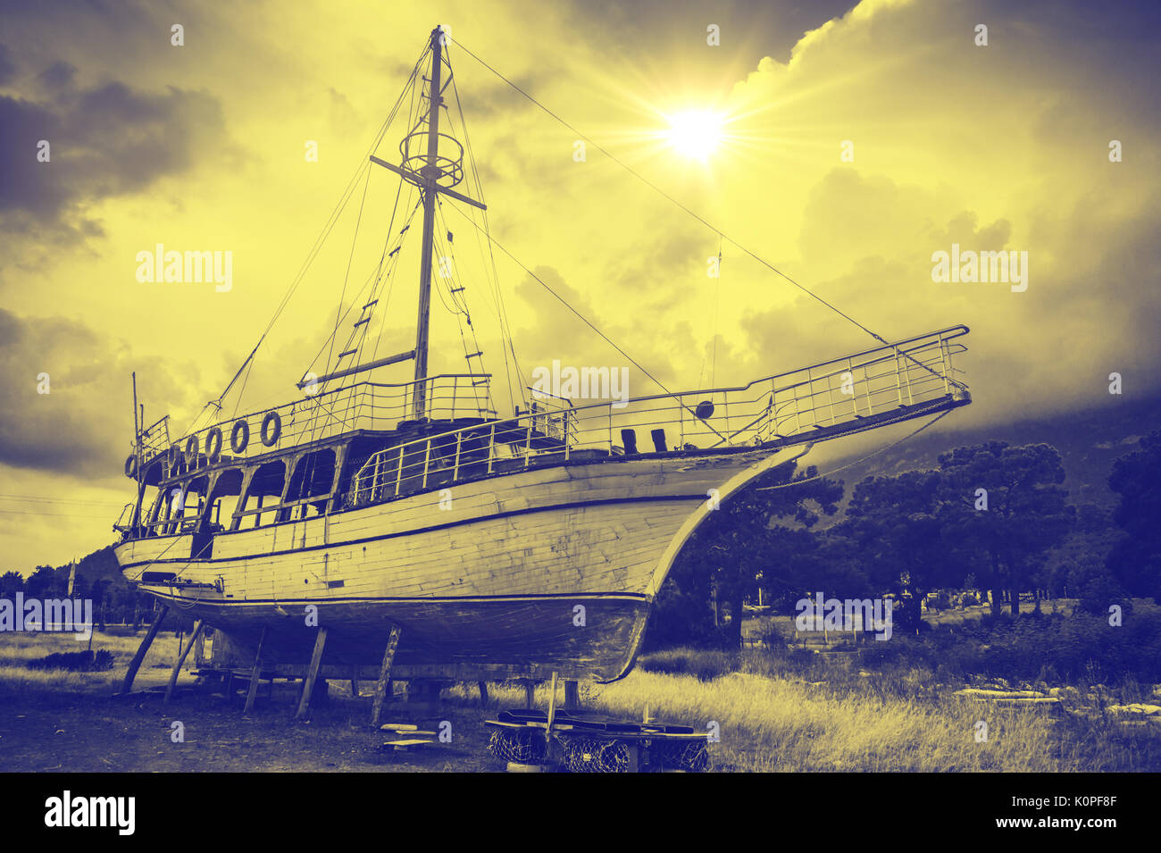Old sailboat in the sun. Yellow and blue tinting. Stock Photo
