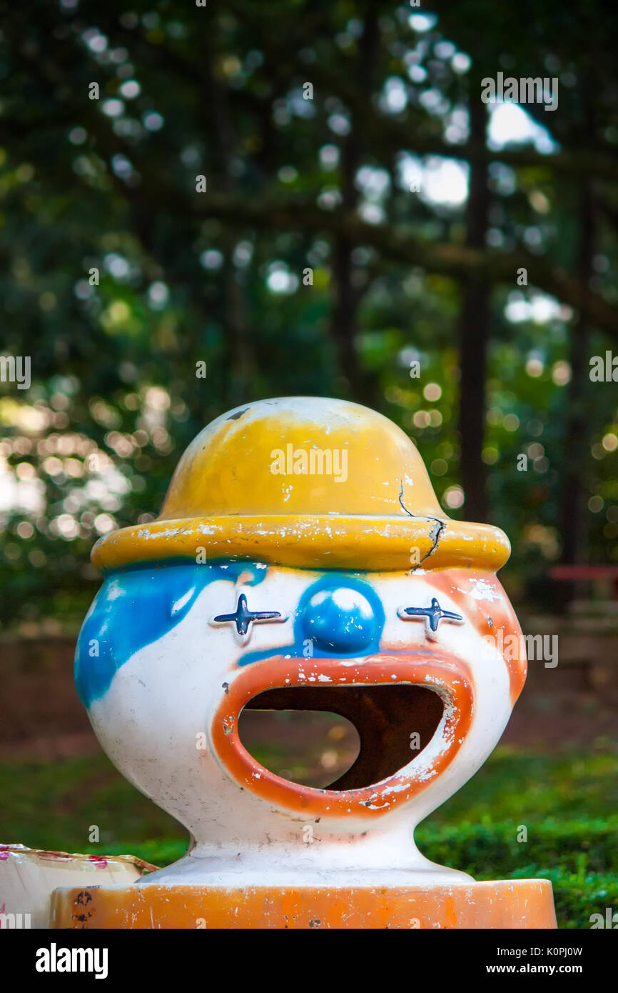 Plastic clown trashcan/wastebasket in an amusement park with big open
