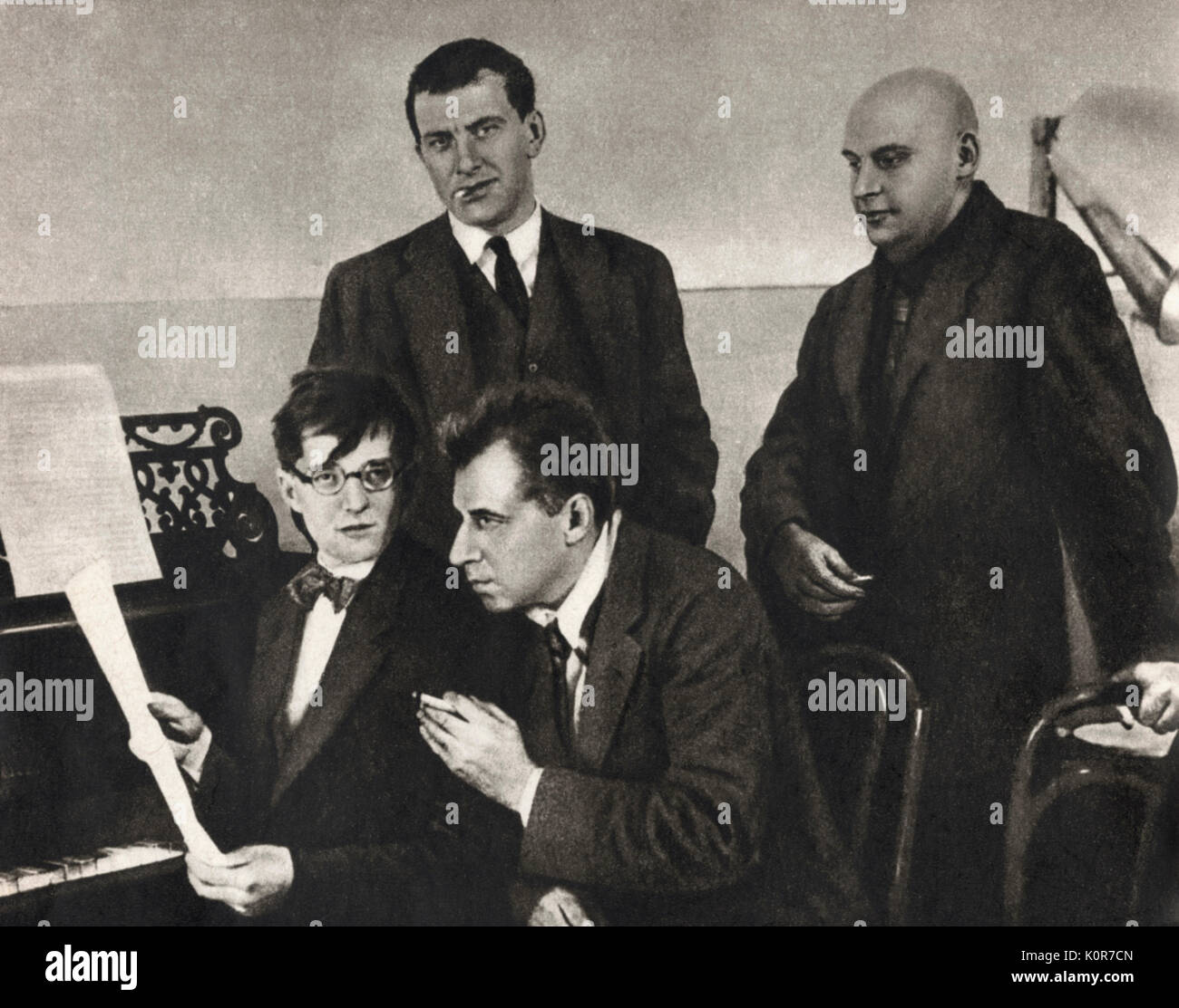 Dmitri Shostakovich in Moscow, 1929.   Schostakowitsch with Mayakovsky (standing l.), Vsevolod Meyerhold (seated)  & Alexander Rodchenko discussing S's music to Mayakovsky's 'Bedbug'.  Russian composer 1906-1975 Stock Photo