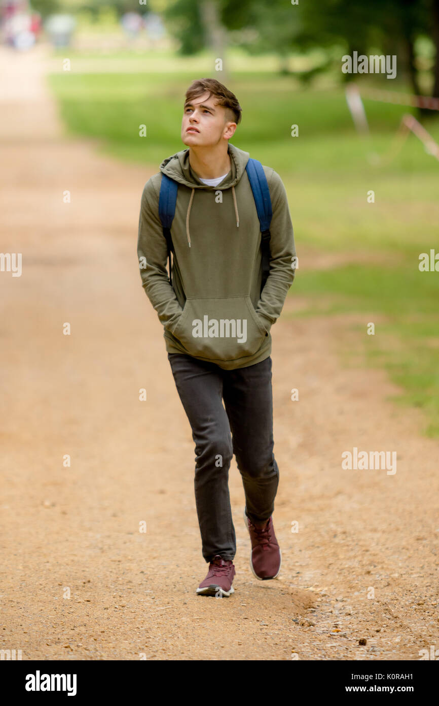 Teenage boy walking in a park on a summers afternoon Stock Photo Alamy