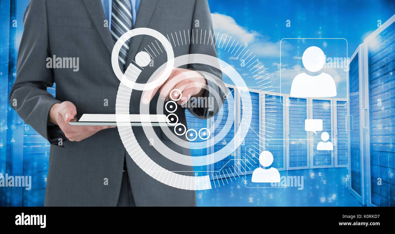 Digital composite of Business man holding a tablet and graphics in server room Stock Photo