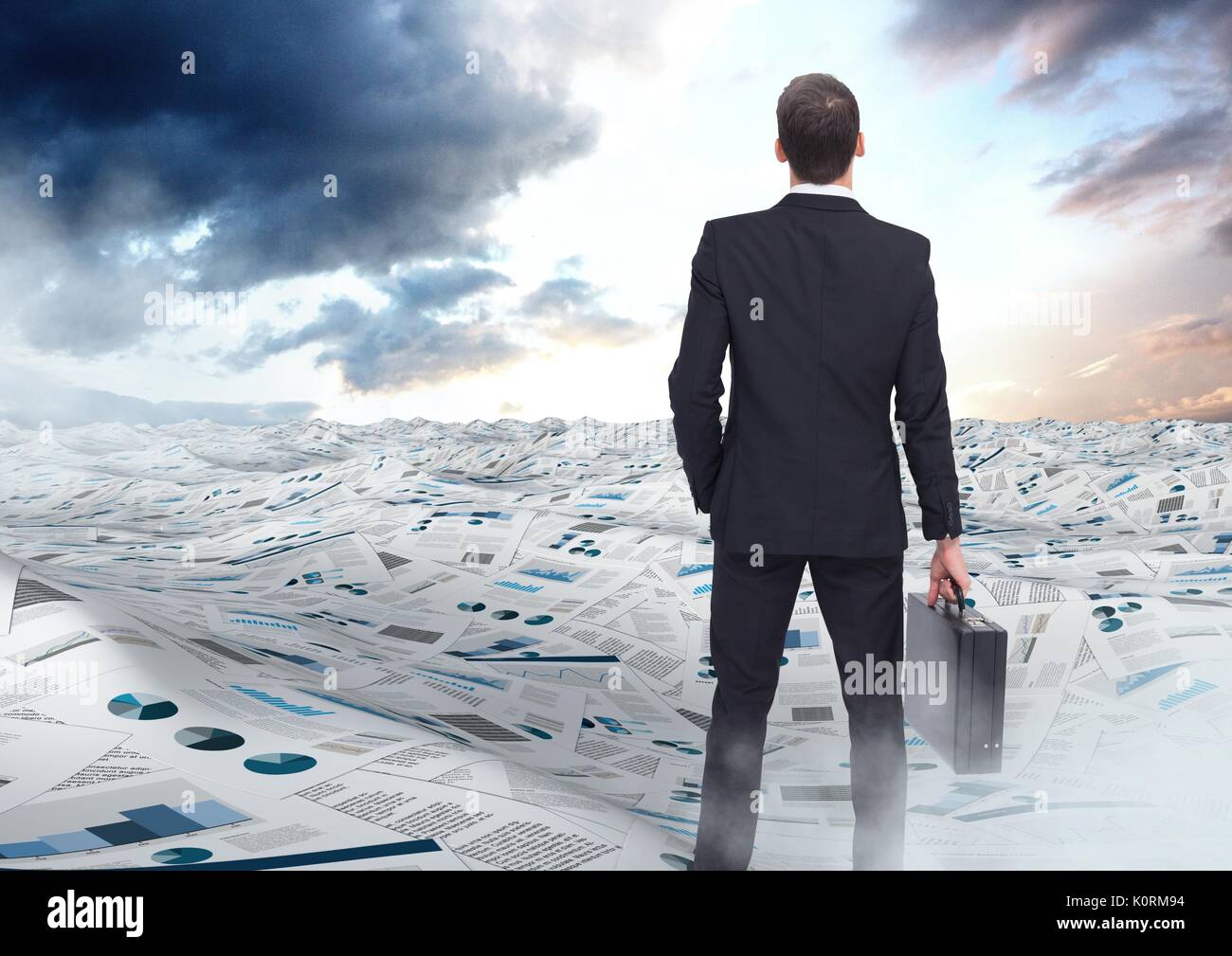 Digital composite of Businessman holding briefcase in sea of documents under sky clouds opening Stock Photo