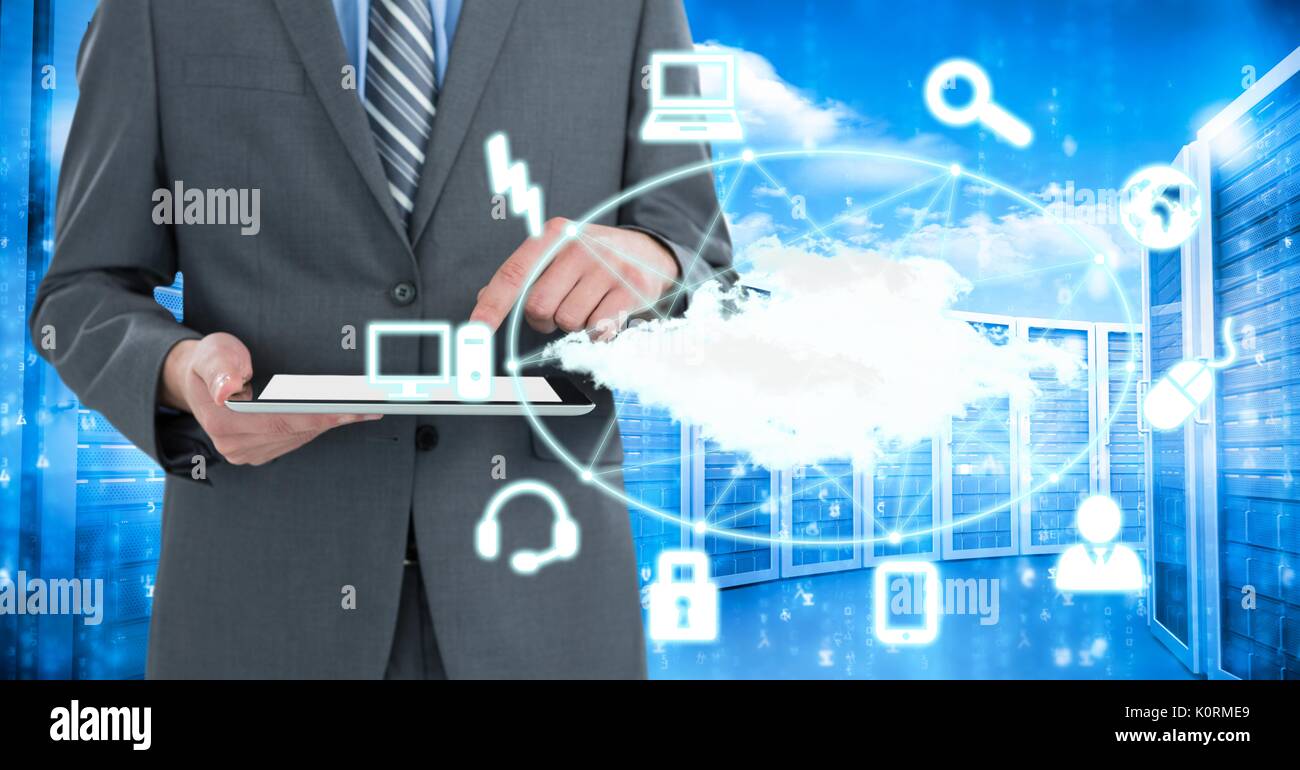 Digital composite of Business man holding a tablet and graphics in server room Stock Photo