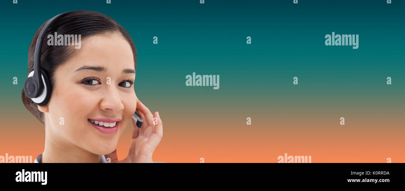 Close up of a smiling operator posing with a headset against orange and turquoise background Stock Photo
