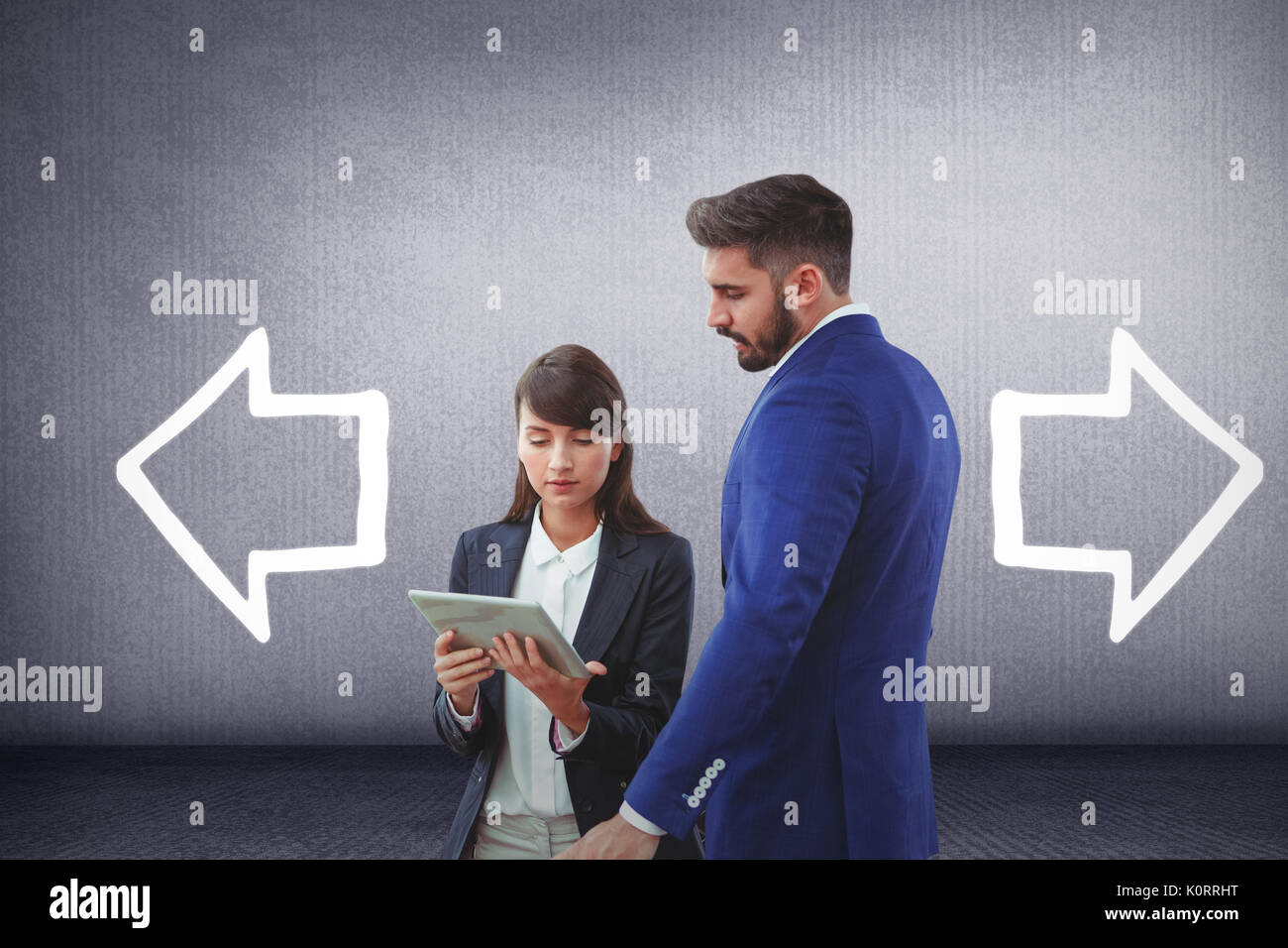 Business colleagues using digital tablet against grey room Stock Photo