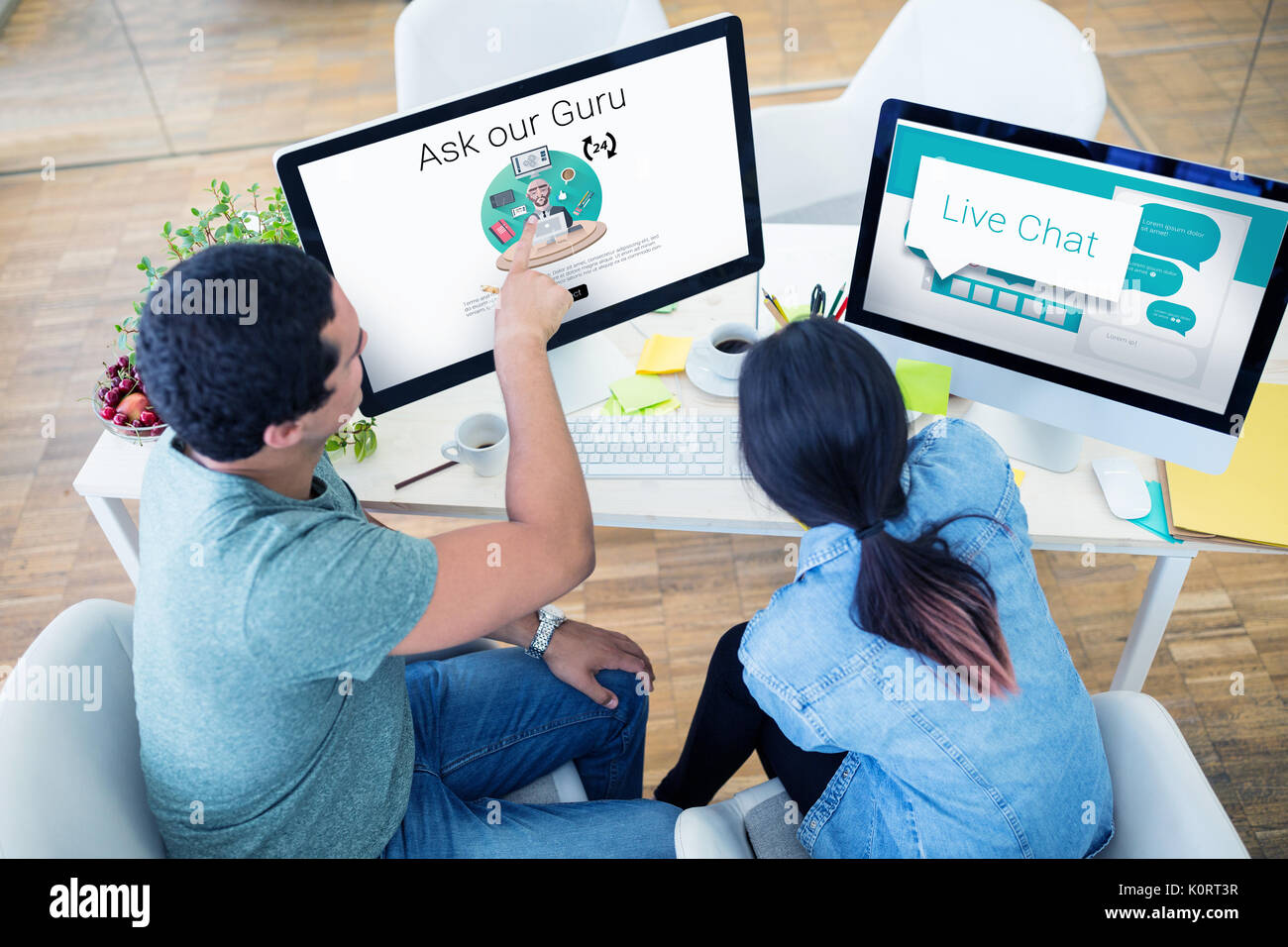 Speech bubbles with live chat text against graphic designers working at desk Stock Photo