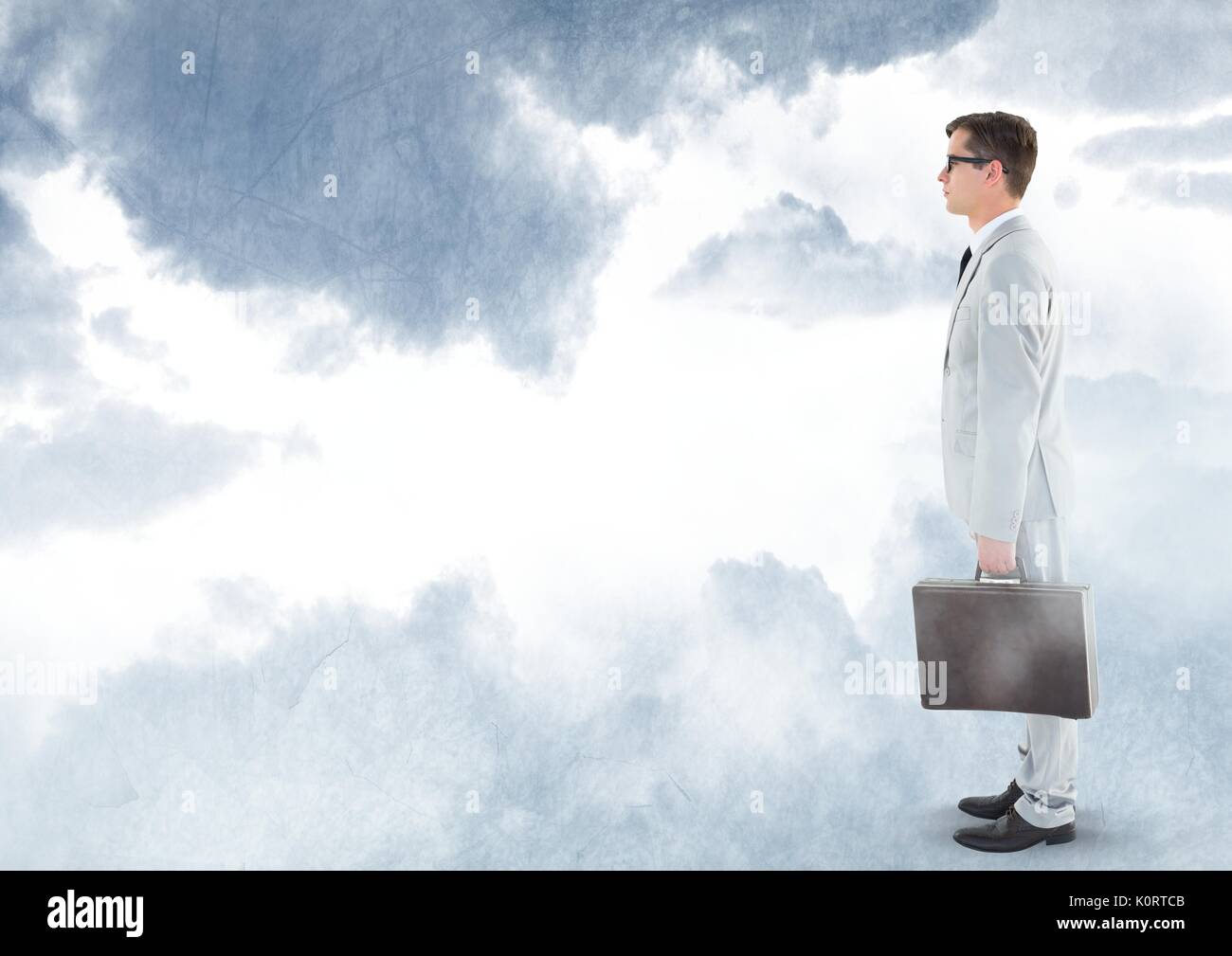 Digital composite of Businessman holding briefcase under sky clouds Stock Photo