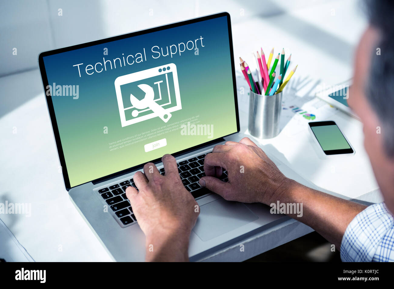Technical support text with tool against overhead of masculine hand typing on laptop Stock Photo