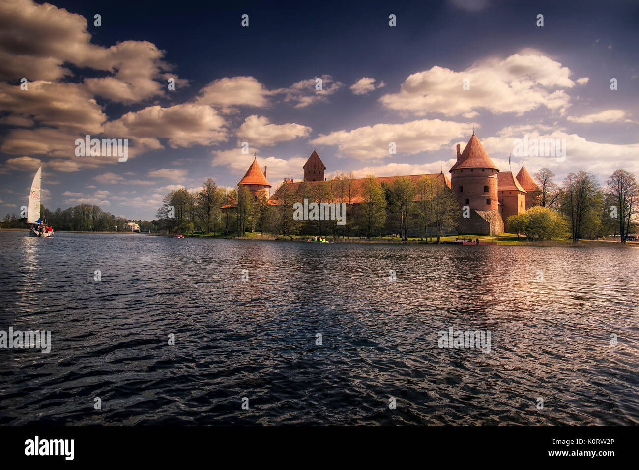 Colorful Lithuanian landscape with Trakai castle and island at Galves Lake. Recreational boats moored Stock Photo