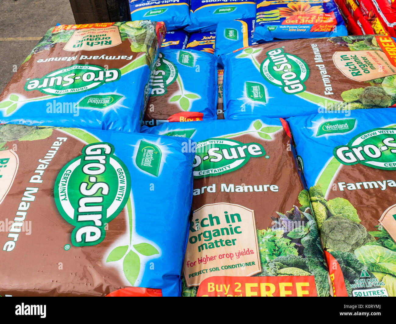 A stack of bags of Growsure Farmyard Manure growing medium high in organic material for high crop yields in a garden centre Stock Photo