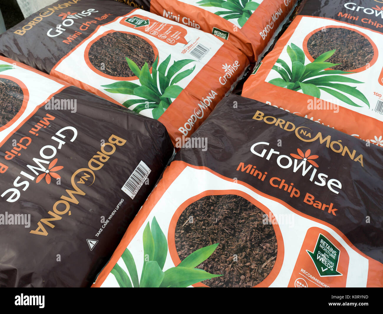 A stack of bags of Bord Na Mona Mini Chip Bark for dressing plant beds to retain moisture and discourage weeds in a garden centre Stock Photo