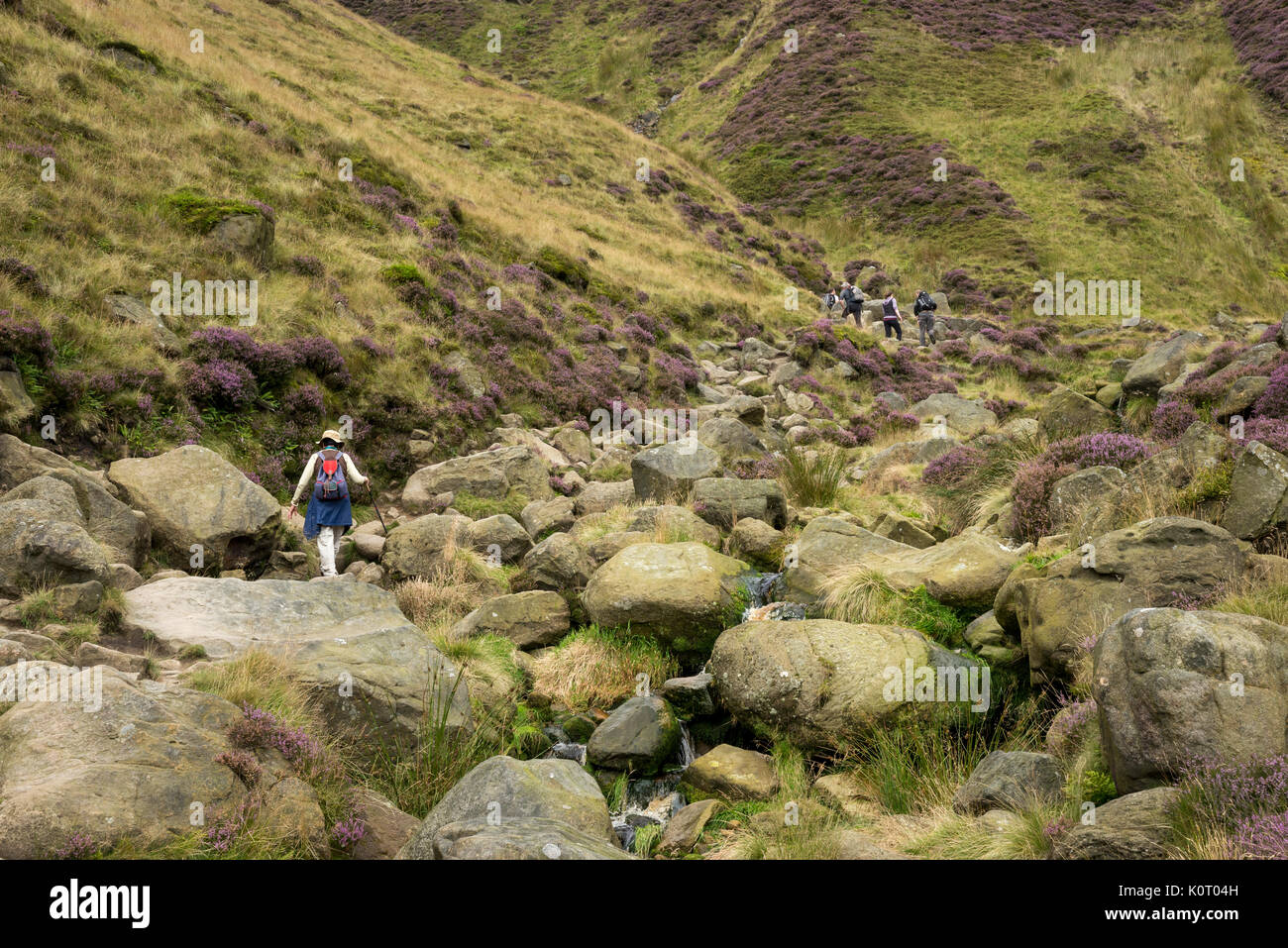 Hill walkers in the rugged landscape of Grindsbrook Clough near Edale in the Peak District national park, Derbyshire, England. Stock Photo