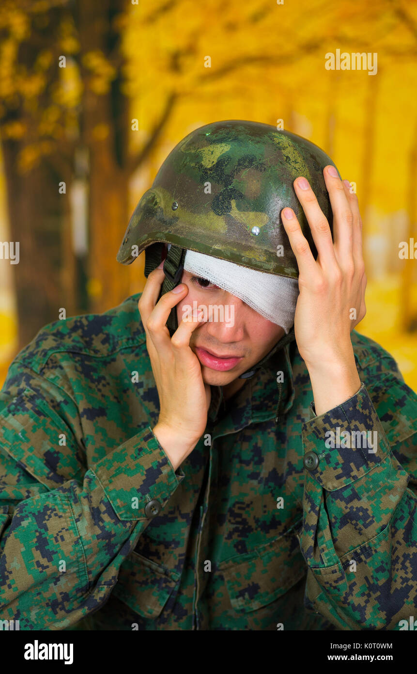 Handsome young soldier wearing uniform suffering from stress, with a