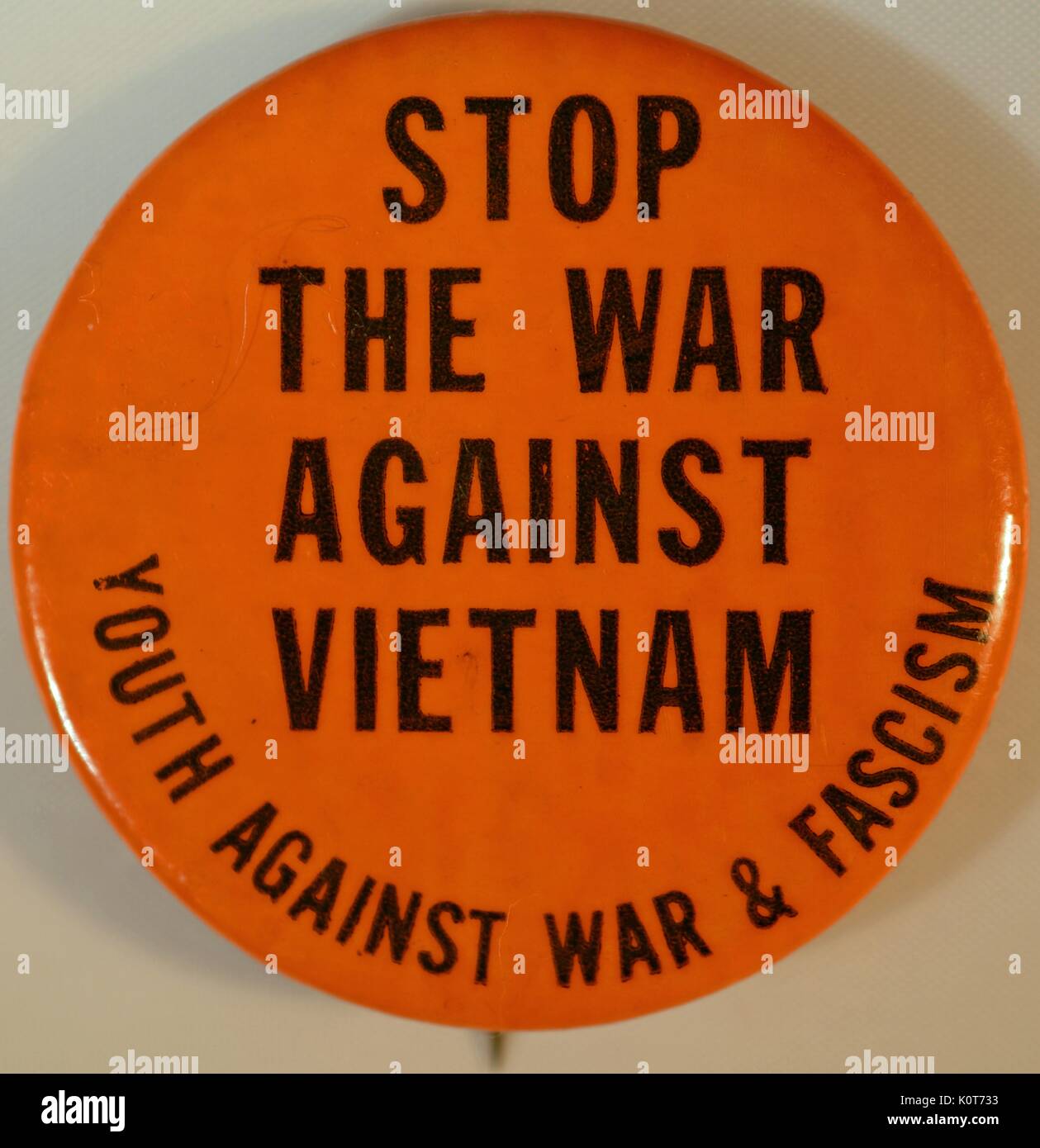 An anti-Vietnam War protest pin that has an orange background and contains the text 'Stop the war on Vietnam', the pin also includes text that reads 'Youth Against War and Fascism', 1968. Stock Photo