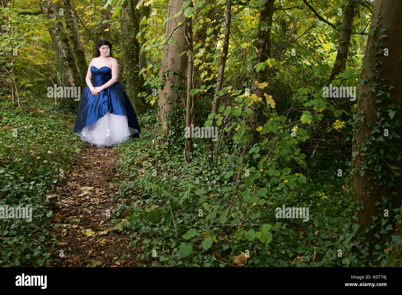 Pretty girl in a forest wearing a long dress Stock Photo - Alamy