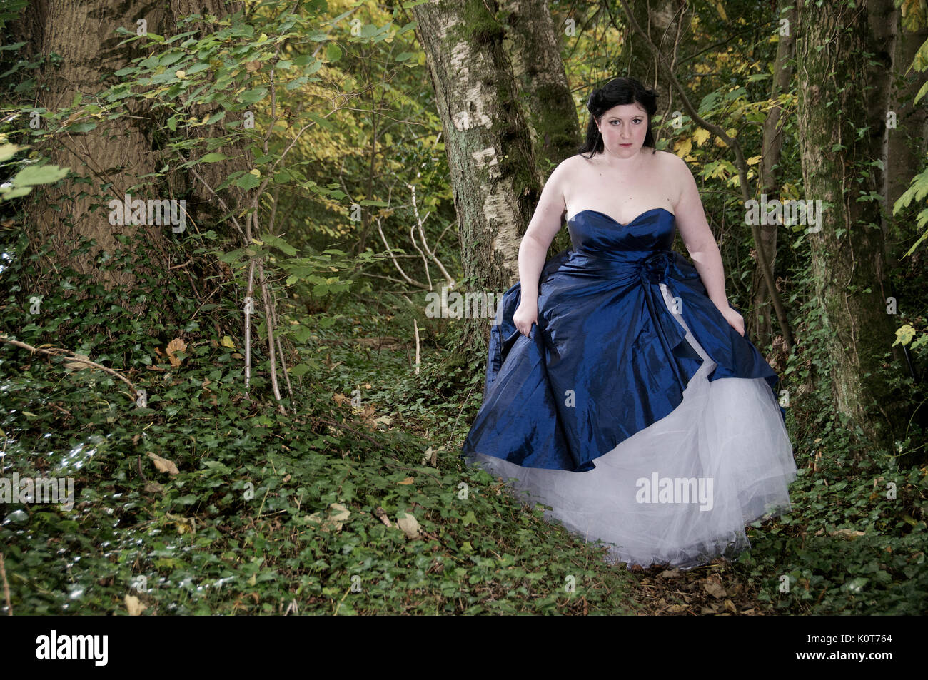 Pretty girl in a forest wearing a long dress Stock Photo - Alamy