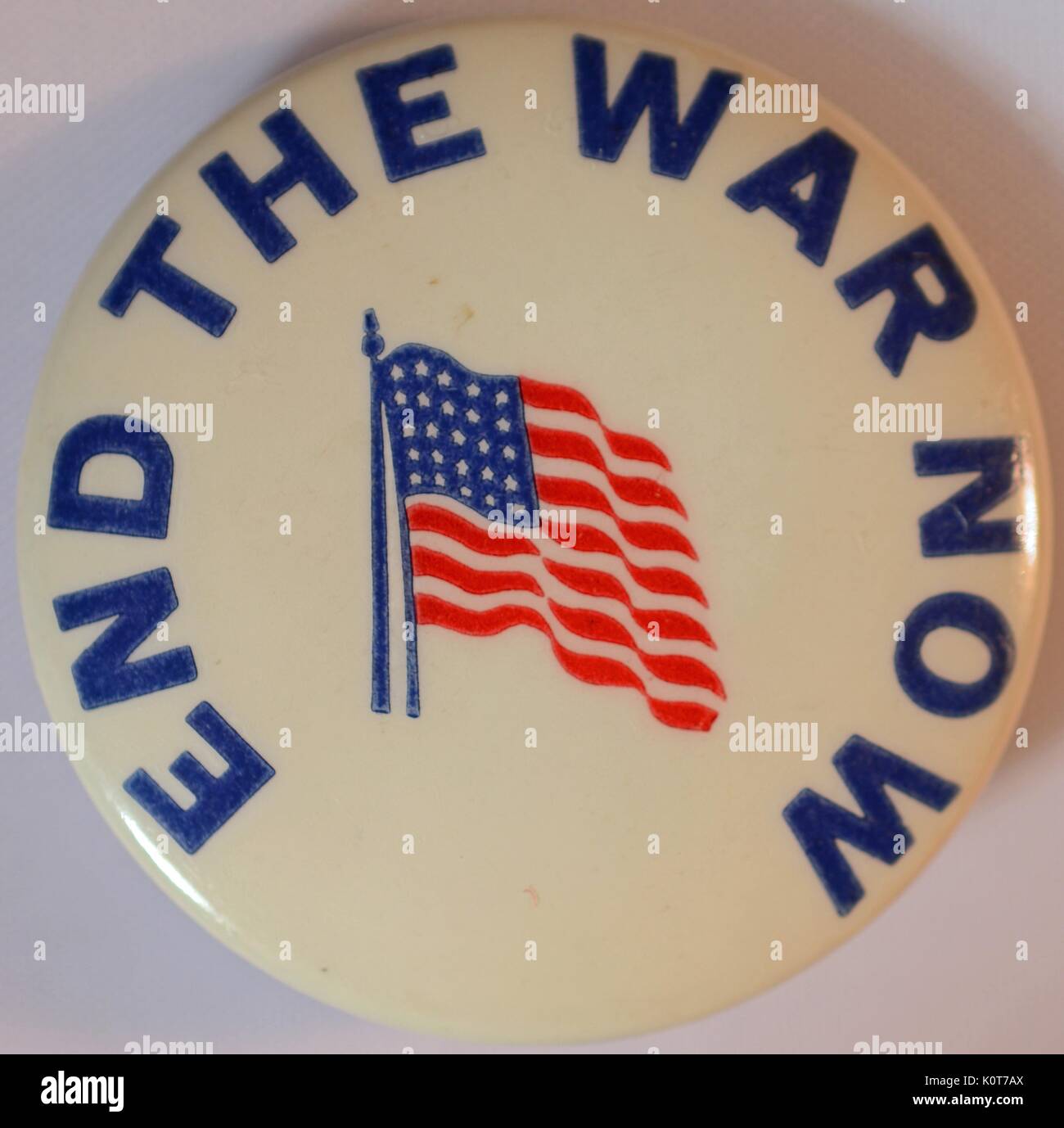 An anti-Vietnam War pin that consists of a white background, the flag of the United States and text that reads 'End the war now', 1968. Stock Photo