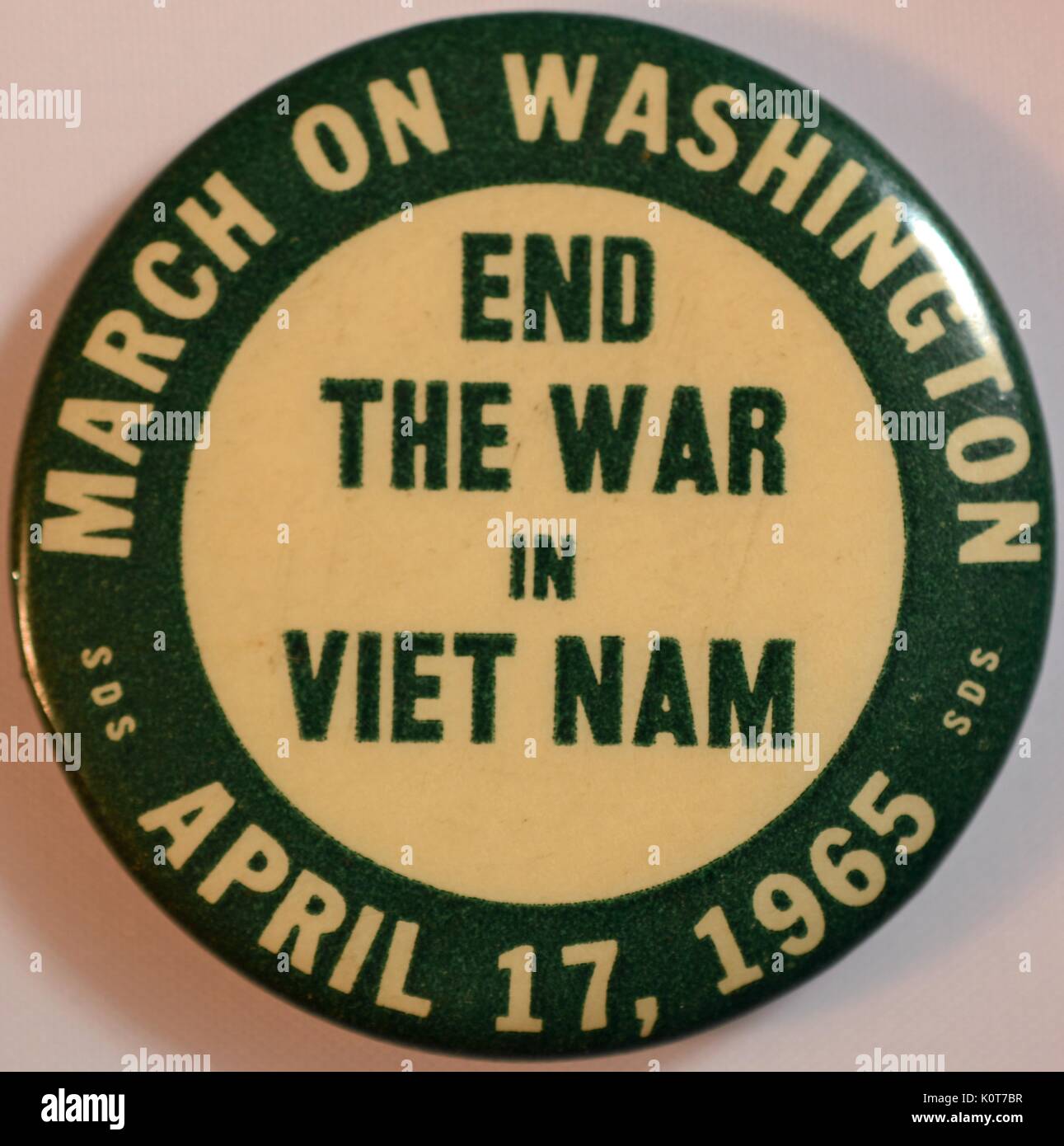 An anti-Vietnam War pin that features the text 'End the war in Vietnam' in the center, text reading 'March on Washington' and 'April 17, 1965' run along the outer edge, also contains the initials 'SDS' for Students For A Democratic Society which was the group that organized the march, 1965. Stock Photo