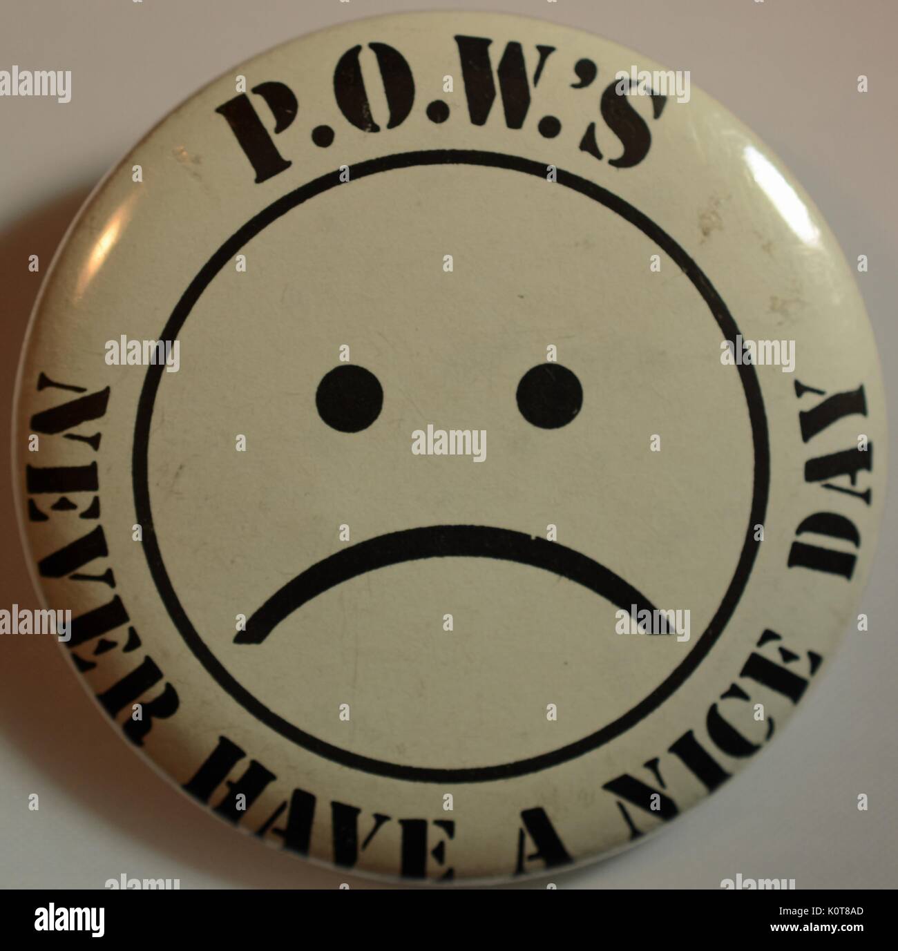 A pin featuring the cartoon representation of a sad, frowning face with the words 'P.O.W.'s never have a nice day', created to maintain awareness of the United States soldiers who were Prisoners of War or Missing in Action in Vietnam, 1968. Stock Photo
