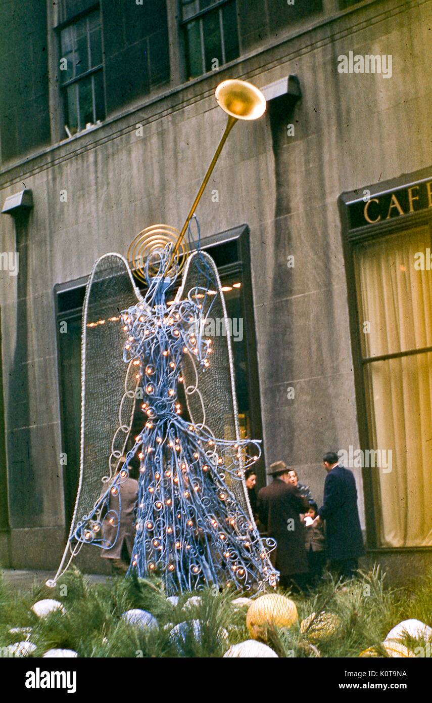 View of a wire sculpture Christmas angel decoration located in the Channel Gardens promenade of Rockefeller Center Plaza, midtown Manhattan, New York City, December, 1955. This trumpeting angel created by artist Valerie Clarebout is an early version of the angel sculptures later placed on permanent display in 1969. Stock Photo