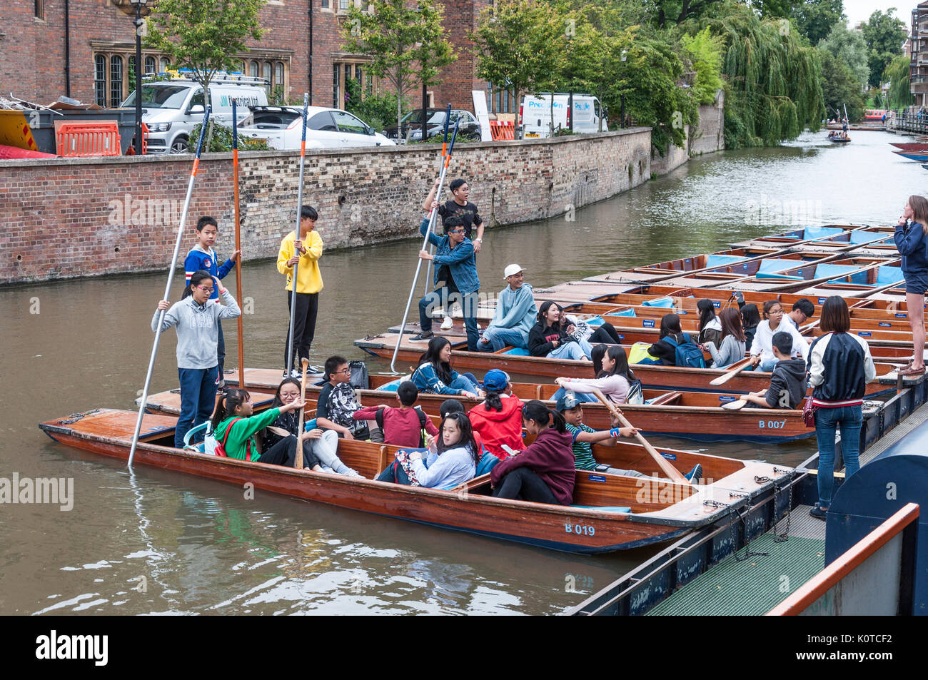 Groups of young people about to set off from the Quayside on a punting excursion on the River Cam, Cambridge, England. Stock Photo