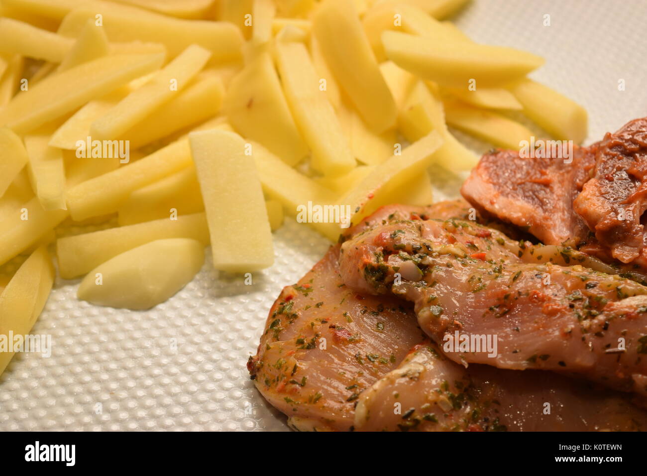Raw chicken and pork fillets with chips Stock Photo Alamy
