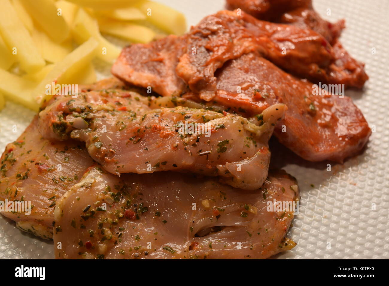 Close up of raw chicken and pork fillets with chips Stock Photo Alamy