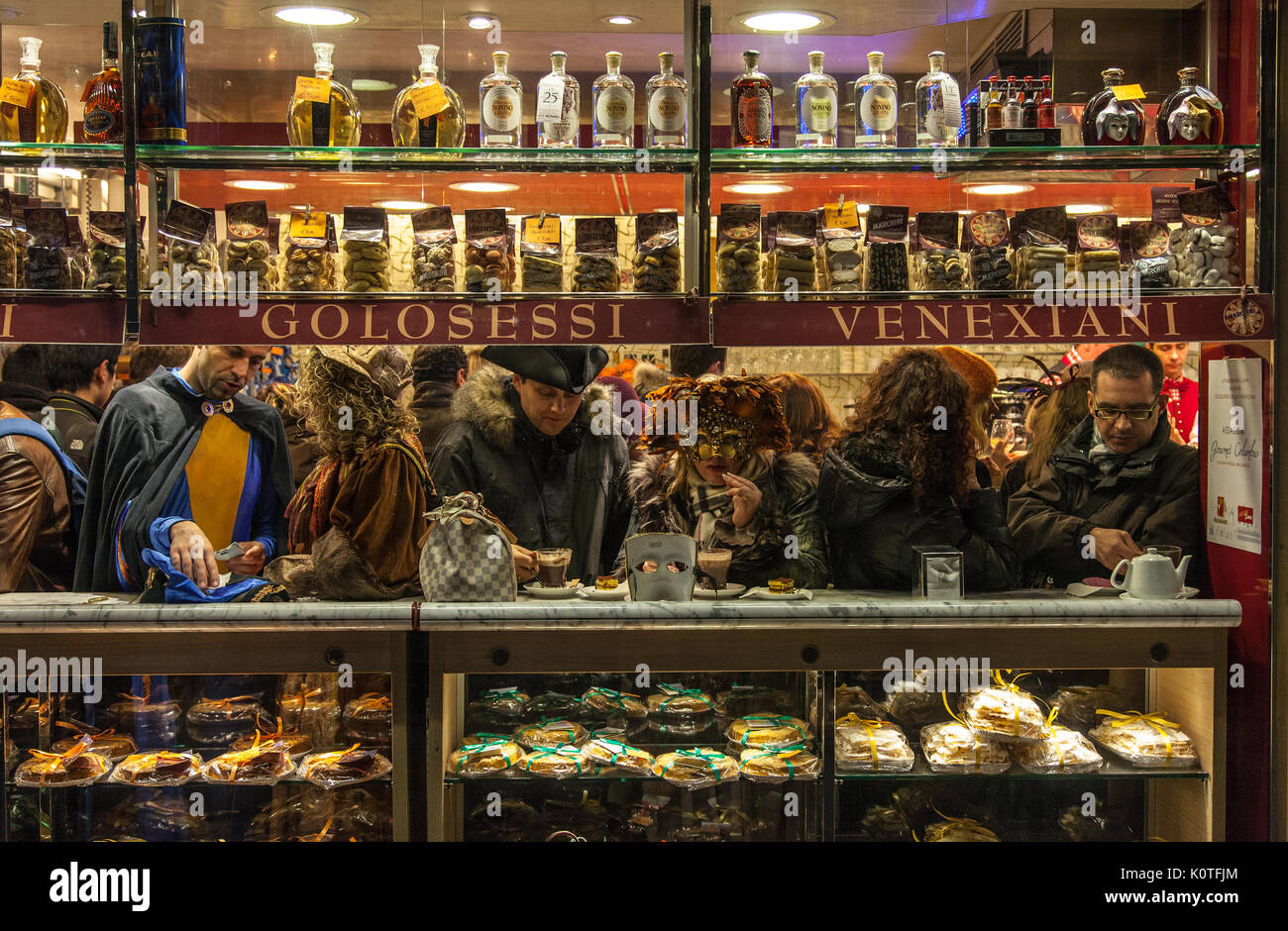 Venice,Italy- February 18, 2012: People wearing various masks enjoy a coffee break in a small Venetian Cafe during the days of Venice Carnival. Stock Photo